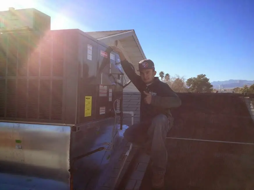 HVAC technician performing Boiler Repair on a rooftop unit in St. Francis